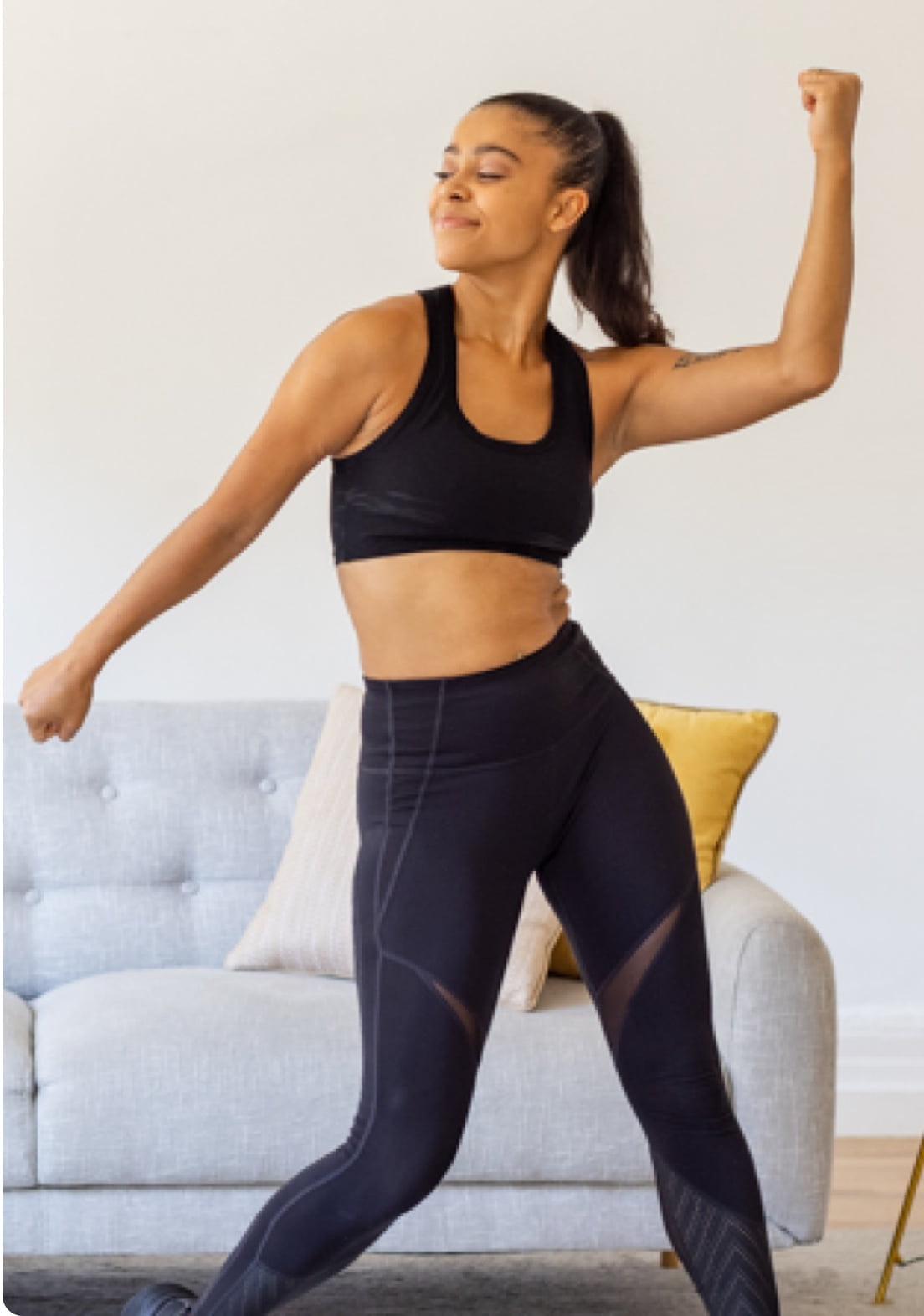 Model enjoying music and dancing in living room with her eyes closed